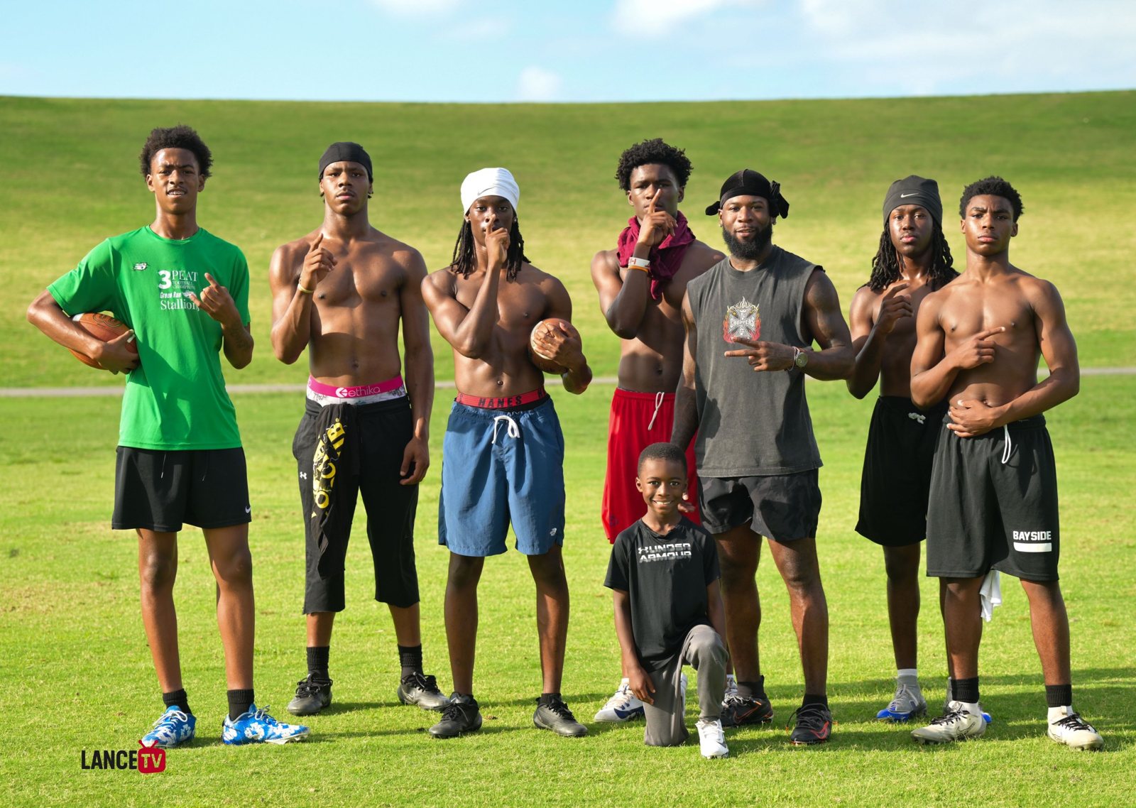 Taquan Mizzell with a group of athletes after a field training session